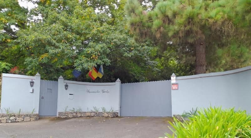 The white entrance gate to the estate, with the track and the valley greenery
