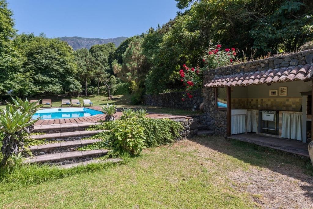 Der Pool der Finca mit Holzterrasse und dem Tal im Hintergrund