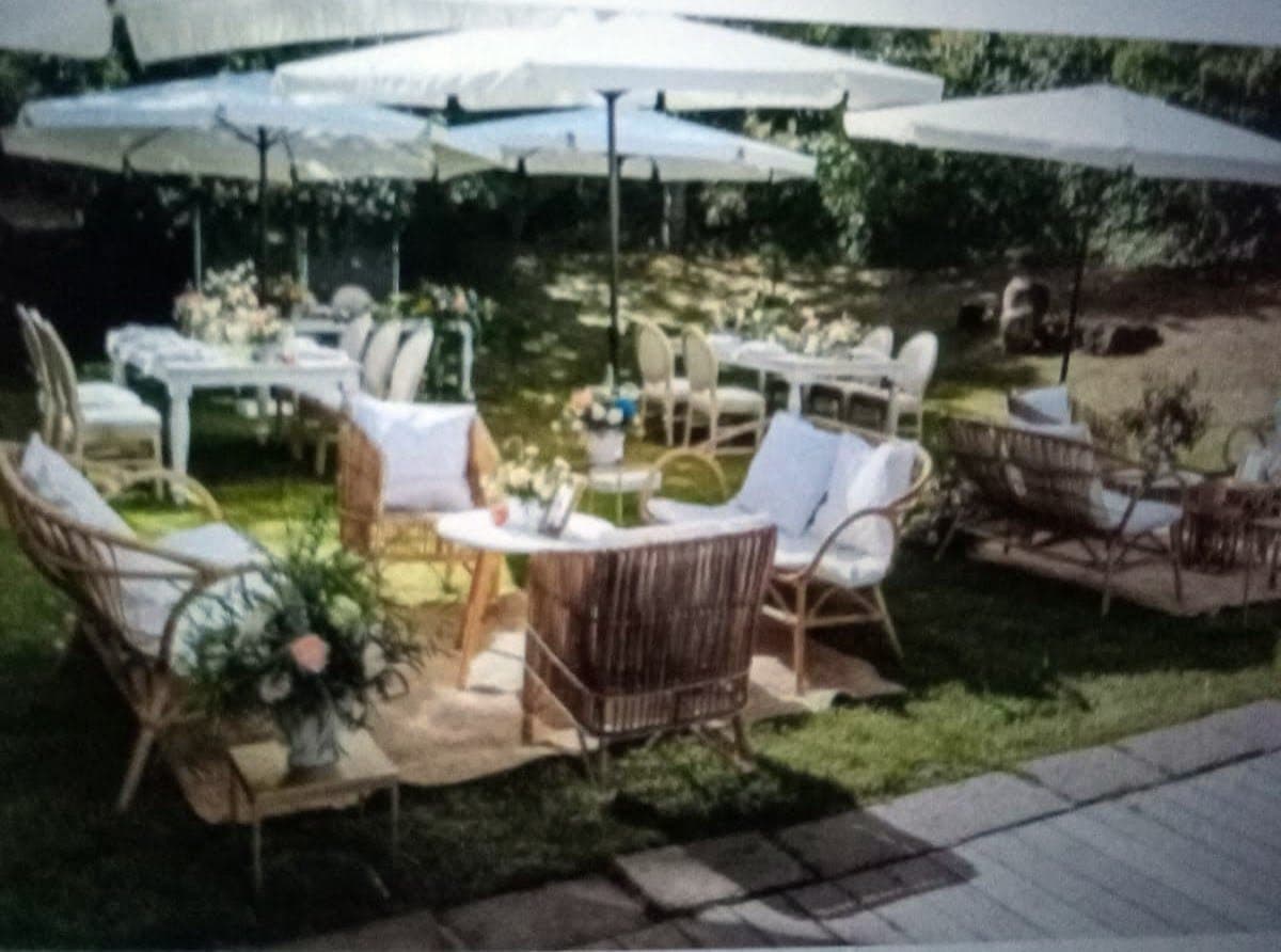 Sitzbereich mit Korbmöbeln und Textilien im Garten der Finca